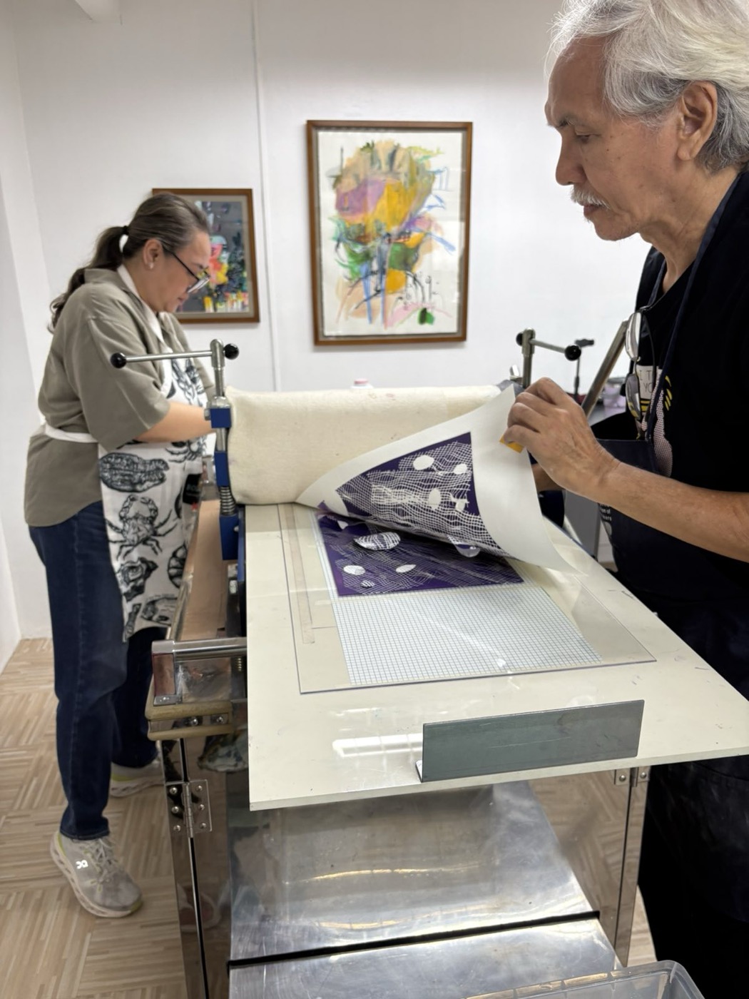 Benjie pulls a fresh print from the press